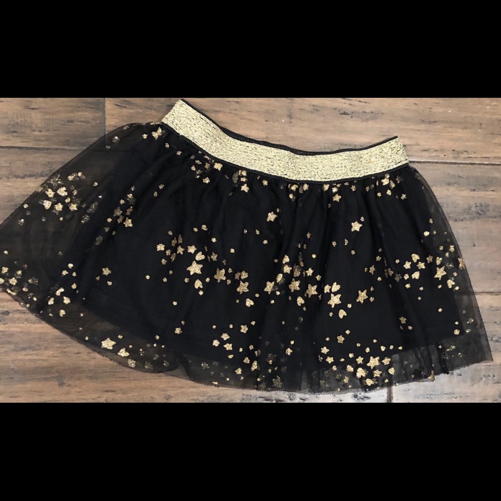 A little girls black skirt with gold star design
